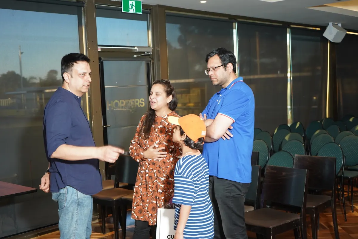 Manan Khurma talking with a family after the Melbourne summit