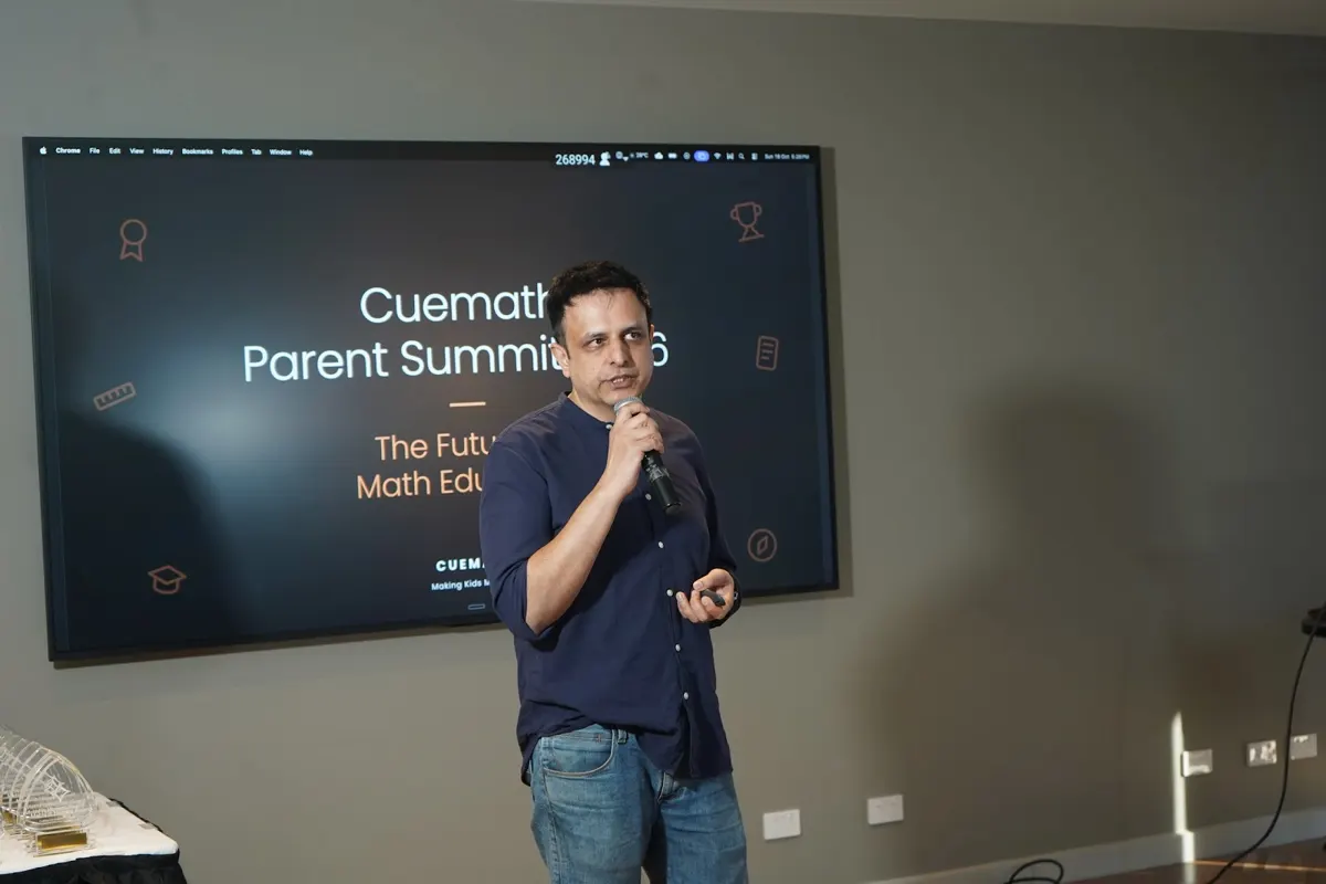 Manan Khurma speaking in front of the summit title slide in Melbourne